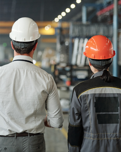 Two men in hardhats at a manufacturing plant